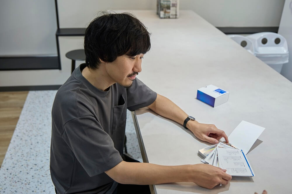 S&D素材のサンプル帳を手にする森本さん