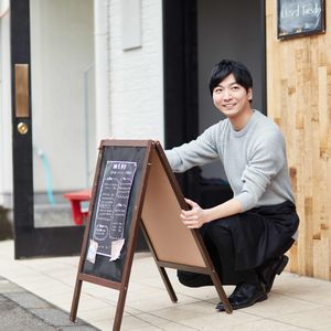 A型看板を設置する飲食店の店員男性