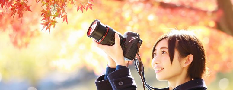 紅葉の写真を撮影する女性