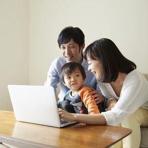 パソコンを操作する両親と男の子